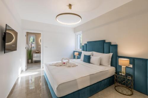 a bedroom with a large bed with a blue headboard at Villa Sun Garden in Bol