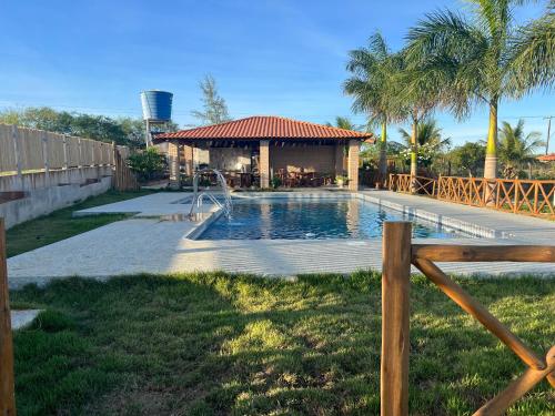 a swimming pool with a gazebo in a yard at Sítio recanto das Palmeiras in Serrinha