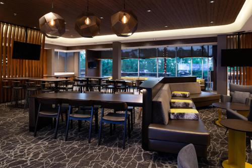 a restaurant with a bar and tables and chairs at SpringHill Suites by Marriott Elizabethtown in Elizabethtown