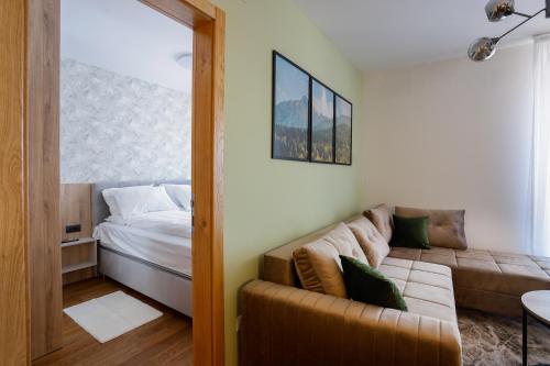 ein Wohnzimmer mit einem Sofa und einem Bett in der Unterkunft Apartmani Aria Jahorina in Jahorina