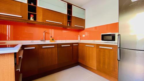 uma cozinha com armários de madeira e um frigorífico de aço inoxidável em Click&Guest - Alisios House in Las Palmas em Las Palmas de Gran Canaria