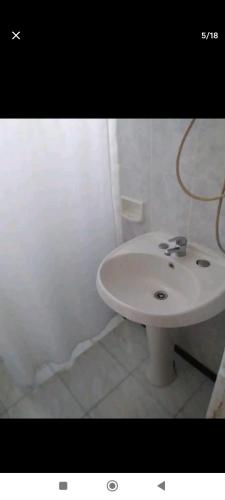 baño con lavabo blanco en una habitación en Carmelo en Carmelo