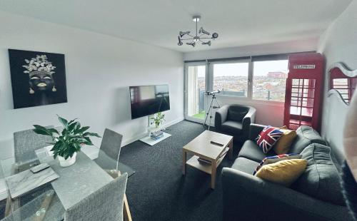 uma sala de estar com um sofá e uma mesa em Unique view of Anfield stadium - Charming 2 bedroom apartment in Liverpool with parking em Liverpool