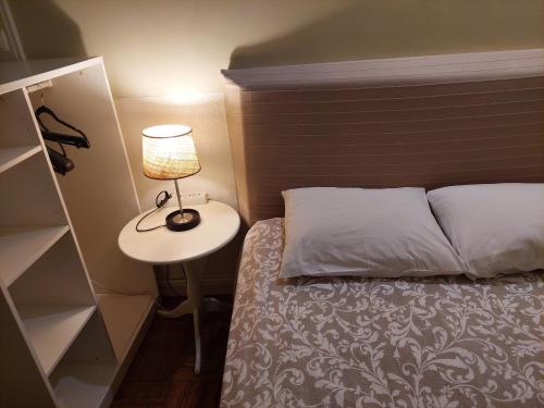 a bedroom with a bed and a lamp on a table at Trindade Apartment in Porto