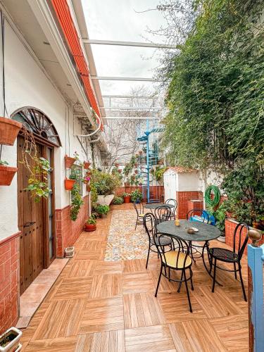 eine Terrasse mit einem Tisch, Stühlen und Pflanzen in der Unterkunft Casa Cruz in Almodóvar del Río