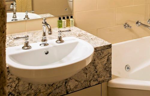 a bathroom with a sink and a bath tub at Castle Keep B&B in the Tower. in Crafers