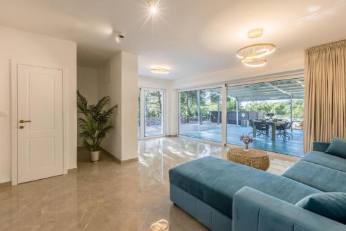 a living room with a blue couch and a sliding glass door at Villa Sun Garden in Bol