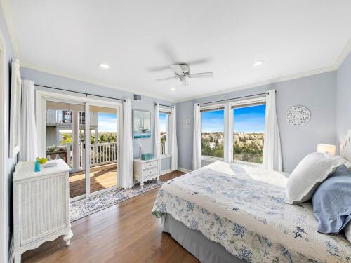 a white bedroom with a bed and a balcony at Beautifully Renovated Ocean Front Home In Harvey Cedars in Harvey Cedars