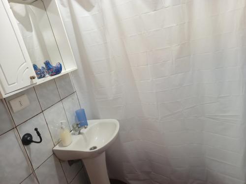 biała łazienka z umywalką i prysznicem w obiekcie HOSPEDAJE POR TEMPORADA VERANO COYHAIQUE w mieście Coihaique