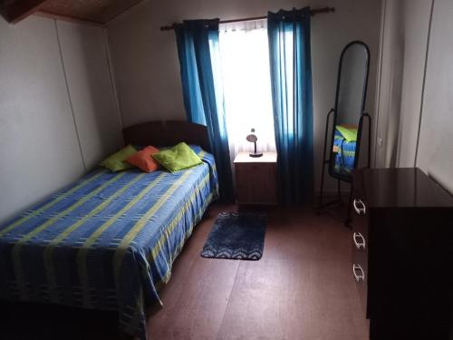 sypialnia z łóżkiem, lustrem i oknem w obiekcie HOSPEDAJE POR TEMPORADA VERANO COYHAIQUE w mieście Coihaique