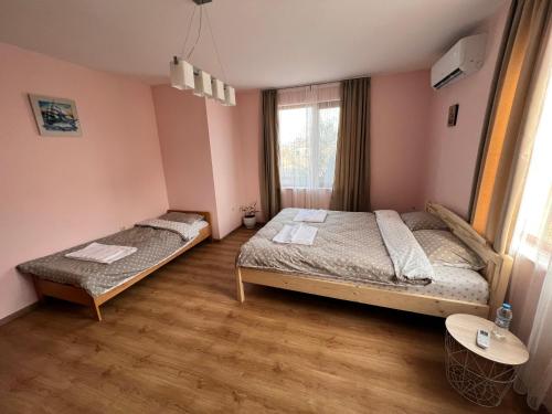 a bedroom with two beds and a window at Къща Каменар in Pomorie