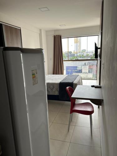 a room with a refrigerator and a table and a bed at Flat com localização privilegiada in Campina Grande