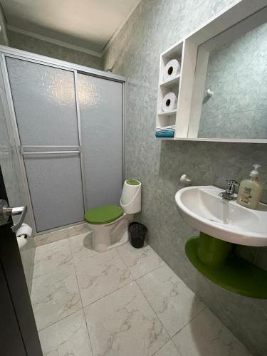 uma casa de banho com um WC verde e um lavatório em CASA EN FLANDES A 10 MIN DE GIRARDOT em Flandes