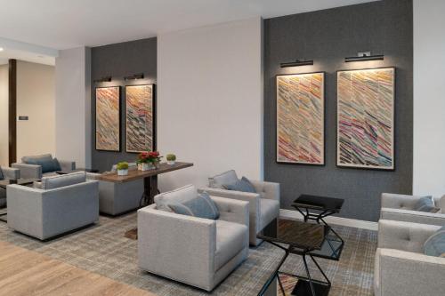 a waiting room with couches and paintings on the wall at Fairfield by Marriott Inn & Suites Framingham in Framingham