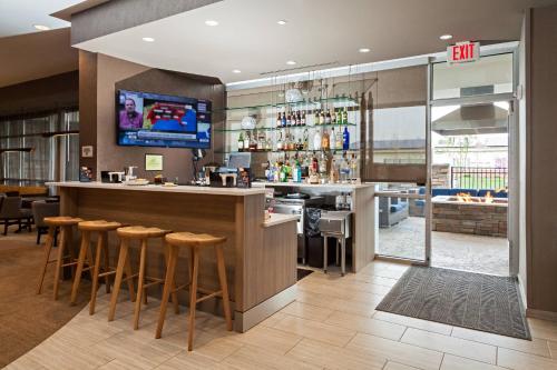 a restaurant with a bar with stools and a tv at SpringHill Suites by Marriott Somerset Franklin Township in Somerset