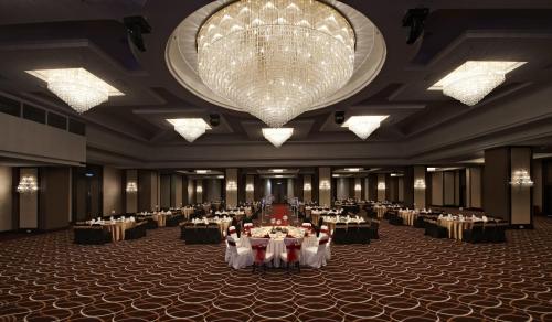 a banquet hall with tables and a large chandelier at Hatten Hotel Melaka in Melaka