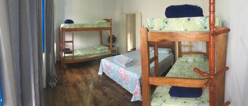 Cette chambre comprend deux lits superposés et un petit lit. dans l'établissement Hostel do Coreto, à Mucugê
