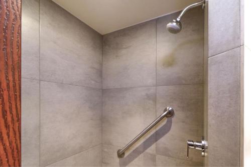 uma casa de banho com um chuveiro com uma pega. em City Express Junior by Marriott Tijuana Otay em Tijuana