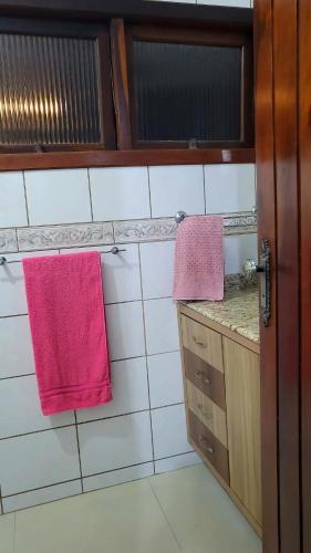 een badkamer met 2 roze handdoeken aan de muur bij Casa Bangtan in Florianópolis