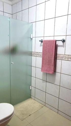 a bathroom with a glass shower with a pink towel at Casa Bangtan in Florianópolis