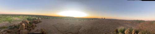a sun setting on top of a rocky hill at Etoko Farm Camp in Uis