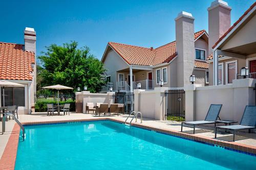 a swimming pool in front of a house at Residence Inn Dallas Las Colinas in Irving