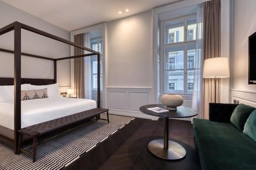 a hotel room with a bed and a couch at Dorothea Hotel, Budapest, Autograph Collection in Budapest