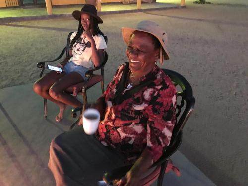 an older man sitting in a chair with a little girl at Etoko Farm Camp in Uis