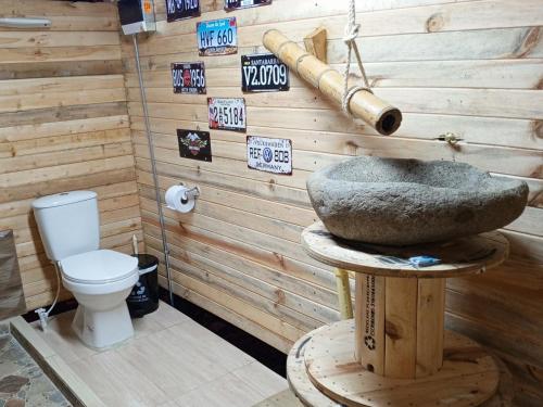 a bathroom with a toilet and a stone sink at Glamping Colibrí, ubicado junto a bosque y cercano al parque a la vez in Jardin