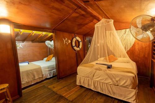 a bedroom with two beds in a cabin at Grand Titanic, Boat House in Punta Allen