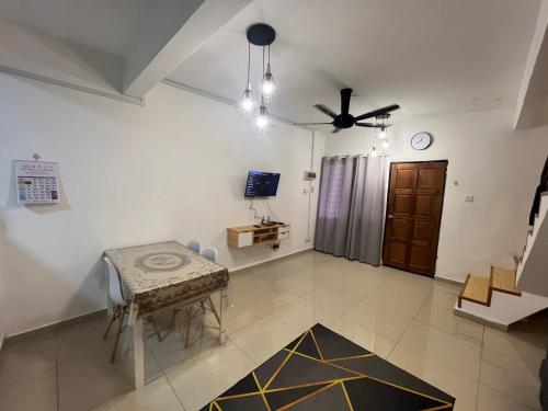 een woonkamer met een tafel en een plafondventilator bij 3BR House near Toll Yong peng in Yong Peng