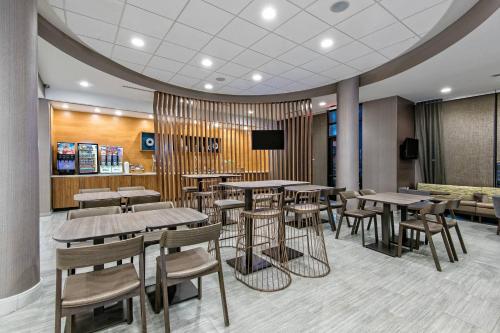 a restaurant with tables and chairs and a tv at SpringHill Suites by Marriott San Antonio Airport in San Antonio