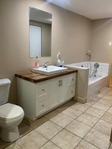 La salle de bains est pourvue d'un lavabo, de toilettes et d'une baignoire. dans l'établissement La Maison Tanguay, à Saguenay