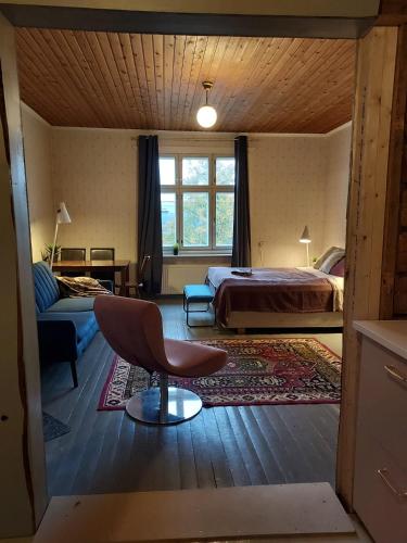 um quarto com uma cama, um sofá e uma cadeira em Entisajan Helmi em Tampere