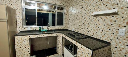 a kitchen with a stove and a window in it at Estância Oliveira in Socorro