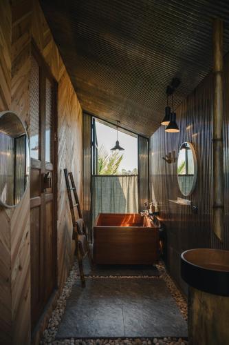 a bathroom with a large tub and a sink at STAY PILAFarm in Ban Nam Chun Yai