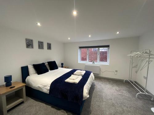 Un dormitorio con una cama grande y una ventana en Modern 3 Bedroom House, Sleeps 6 - Free Parking & Garden - Opposite Racecourse, Near City Centre & Hospital, en Doncaster