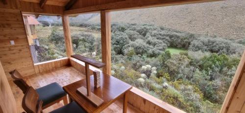an empty room with a table and chairs in a cabin at Espeletia Lodge in El Ángel