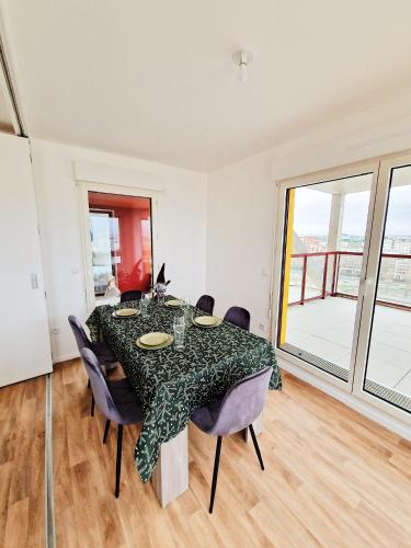 une salle à manger avec une table et des chaises dans l'établissement CHARMING APARTMENT WITH PANORAMIC SEINE RIVER & EIFFEL TOWER VIEWs, à Ivry-sur-Seine