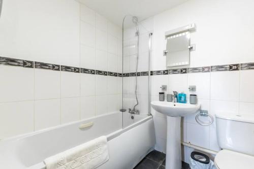 ein weißes Badezimmer mit einem Waschbecken und einer Badewanne in der Unterkunft Jasper- 2 Bed Flat With Parking in Southampton