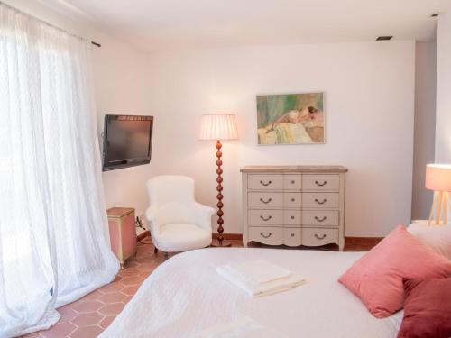 1 dormitorio con 1 cama, 1 silla y TV en La Bastide Romaine, en Entrecasteaux