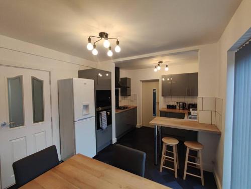 a kitchen with a table and a white refrigerator at House in Great Barr, with parking and garden in Birmingham