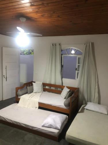 1 dormitorio con 2 camas y ventana en Casa de Família com Ar Condicionado, Garagem e Pet friendly, en Búzios