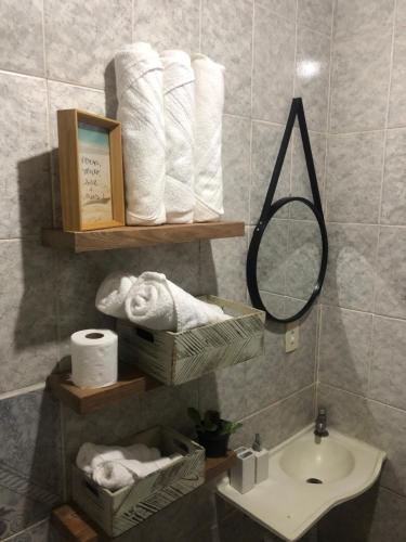 y baño con toallas, lavabo y espejo. en Casa de Família com Ar Condicionado, Garagem e Pet friendly, en Búzios