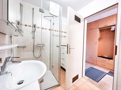 uma casa de banho com um lavatório e uma cabina de duche em vidro. em Lizzys Klause em Oberreute