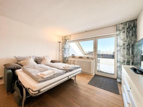 um quarto com uma cama e uma grande janela em Lizzys Klause em Oberreute