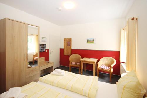 a bedroom with a bed and a desk and chairs at Mollibahnhof - Heiligendamm Mollibahnhof Heiligendamm DZ 04 in Heiligendamm