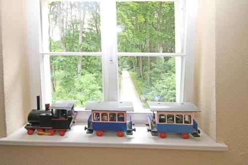 a toy train sitting on top of a window sill at Mollibahnhof - Heiligendamm Mollibahnhof Heiligendamm DZ 04 in Heiligendamm