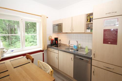 a kitchen with a table and a sink and a counter at Mollibahnhof - Heiligendamm Mollibahnhof Heiligendamm EZ 03 in Heiligendamm