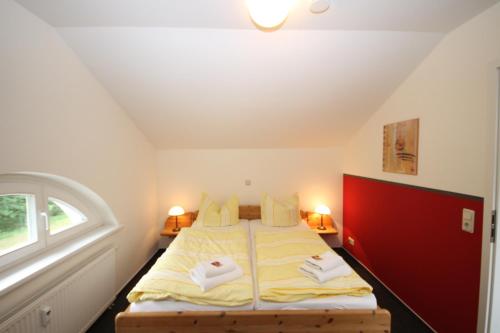 a bedroom with a bed with two towels on it at Mollibahnhof - Heiligendamm Mollibahnhof Ferienwohnung 05 in Heiligendamm